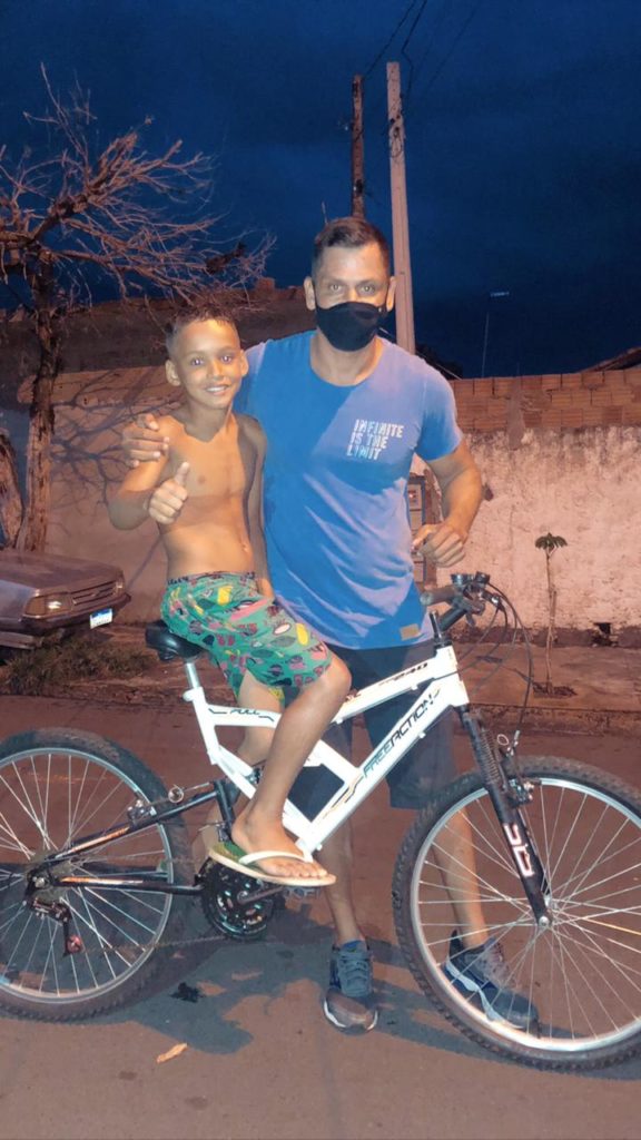 sargento doa bicicleta a menino que perdeu pai assassinado;  ambos posam para uma foto